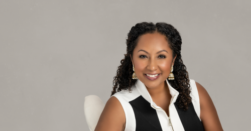 Deanna Singh posing in a chair in front of a gray wall