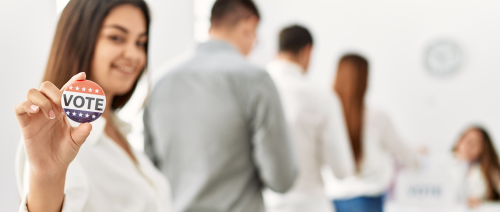 Election voters in line with woman holding a vote button.