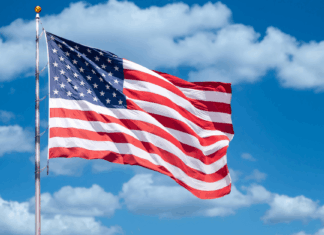 America 250: Experts on America’s Founding and Future American flag against backdrop of blue sky and clouds