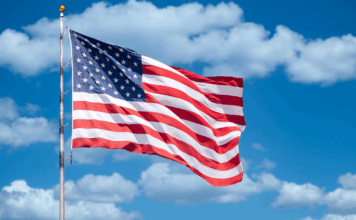 America 250: Experts on America’s Founding and Future American flag against backdrop of blue sky and clouds
