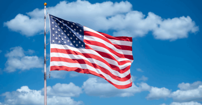 Speakers for America 250 American flag against backdrop of blue sky and clouds
