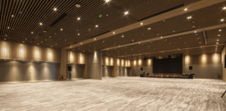 Empty corporate event ballroom with stage and presentation screen