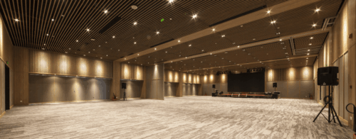 Empty corporate event ballroom with stage and presentation screen