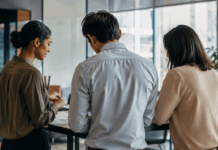 Leading Through Uncertainty: Speaker Strategy for 2026 Events Three business professionals engaged in earnest discussion about organizational strategy in a modern office environment