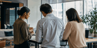 Three business professionals engaged in earnest discussion about organizational strategy in a modern office environment