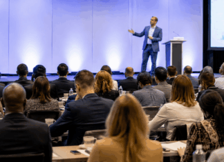Speaker Customization: Evaluating Depth Before Booking Professional event setting with engaged audience listening to a speaker on stage, representing the high stakes and importance of speaker selection and customization.